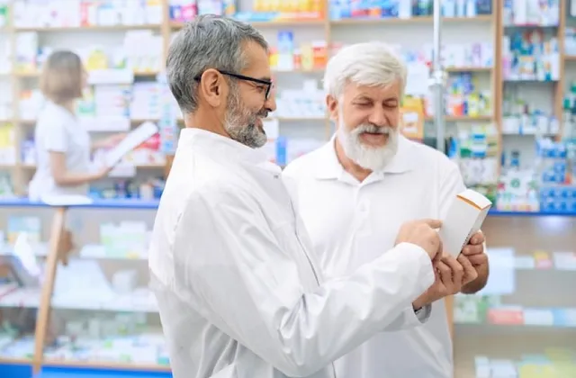 Apotheker erklärt einem älteren Mann sein Rezept