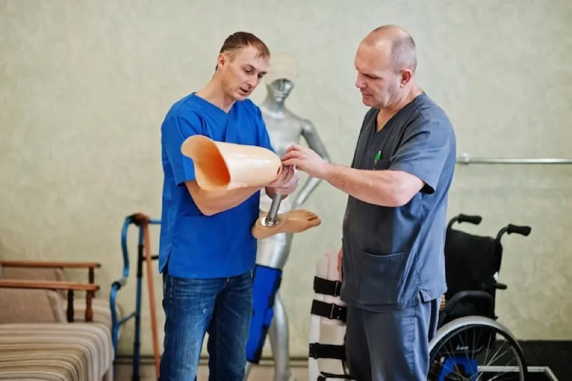 Zwei Orthopädietechniker arbeiten in der Werkstatt an einer Beinprothese